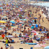 A crowded beach with lots of colourful umbrellas