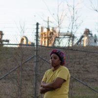 Gloster, Mississippi, resident Jasmine Jenkins stands in front of the Drax plant Amite Bioenergy, which began operations next to her community in 2014.