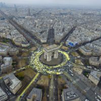 Traffic spreading bright yellow paint from the Arc de Triomphe onto surrounding roads, creating the shape of a sun when seen from above.
