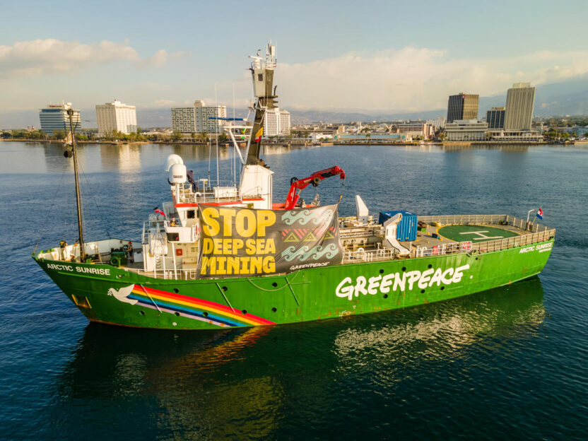Greenpeace ship displaying a giant banner that says stop deep sea mining