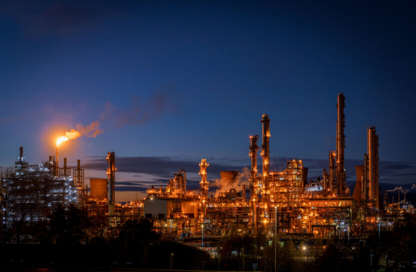 A petrochemical plant photographed at night with a flare visible.