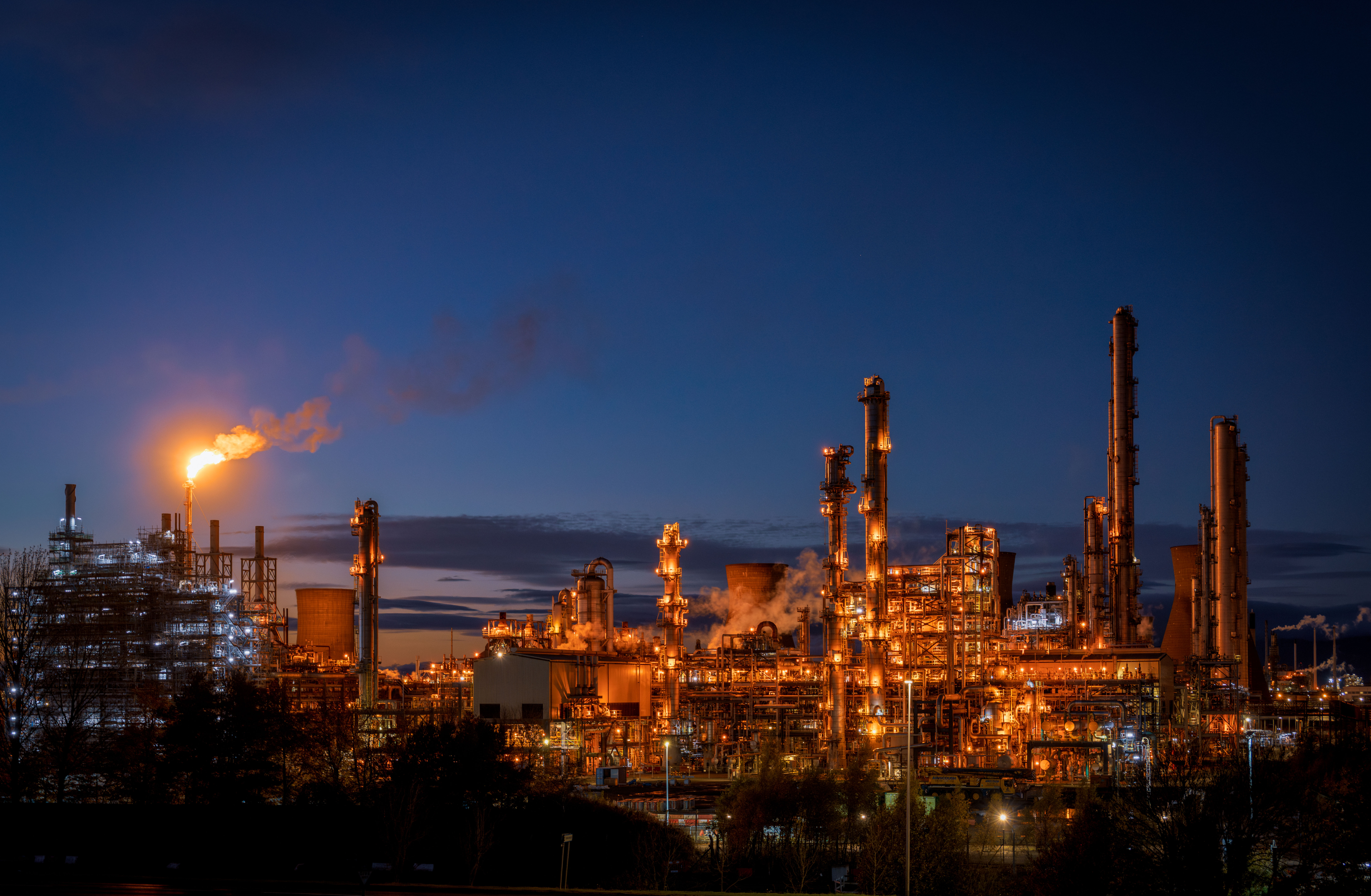 A petrochemical plant photographed at night with a flare visible.